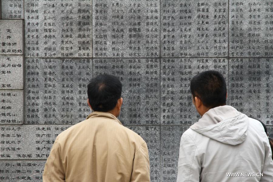 Visitors view a memorial wall on which names of the Nanjing Massacre victims are engraved at the Memorial Hall of the Victims in Nanjing Massacre by Japanese Invaders in Nanjing, capital of east China's Jiangsu Province, March 30, 2013, ahead of the Qingming Festival, or Tomb Sweeping Day, which falls on April 4 this year. (Xinhua/Xu Yijia)