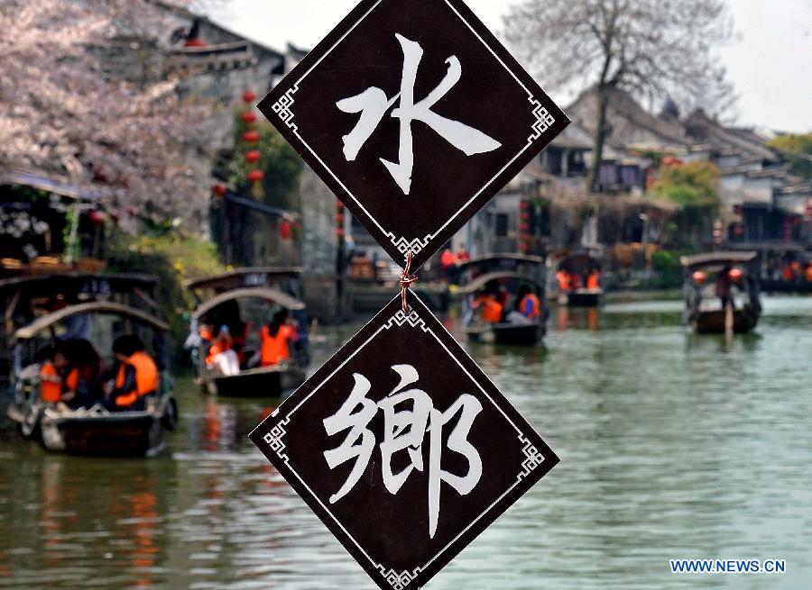 Visitors take boats while touring in the Xitang Township of Jiaxing City in east China's Zhejiang Province, March 30, 2013. Xitang, a township which enjoys thousand years' history, embraced large numbers of visitors recently. (Xinhua/Wang Song)