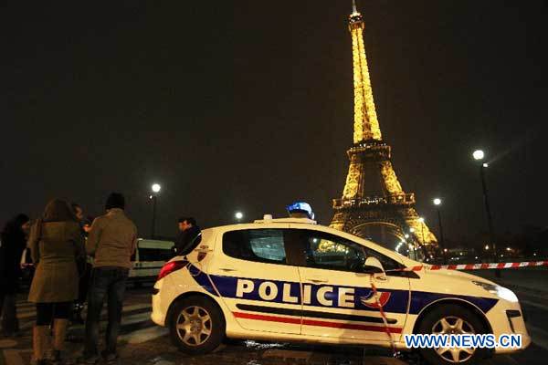 A police car is seen near the cordoned off Eiffel Tower in Paris on March 30, 2013. Local police evacuated around 1,500 people from Paris' icon tower, La Tour Eiffel, on Saturday evening after receiving an anonymous call of bomb attempt from a phone booth near a suburb of Paris. (Xinhua/Gao Jing)