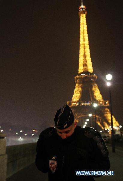 A French police stands guard near the Eiffel Tower in Paris on March 30, 2013. Local police evacuated around 1,500 people from Paris' icon tower, La Tour Eiffel, on Saturday evening after receiving an anonymous call of bomb attempt from a phone booth near a suburb of Paris. (Xinhua/Gao Jing)