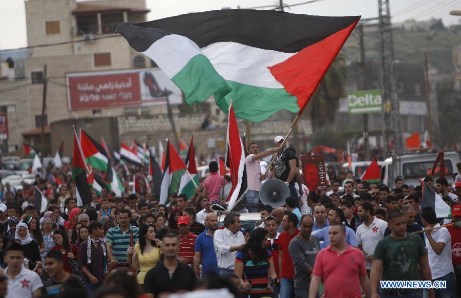 Israeli Arabs wave Palestinian flags during a demonstration marking Land Day in Israeli northern town of Sakhnin on March 30, 2013. Land Day is the annual commemoration of protests in 1976 against Israel's appropriation of Arab-owned land in Galilee. (Xinhua/Muammar Awad)