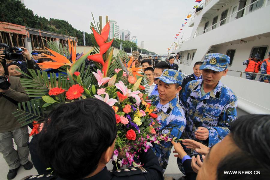 People send flowers to crew members on Chinese fishery patrol ship 44608 for their return at Yuzheng port in Shantou, south China's Guangdong Province, March 30, 2013. The patrol ship 44608 finished its 23-day patrol cruise around Huangyan Islands on Saturday and returned to Shantou. (Xinhua/Yao Jun)
