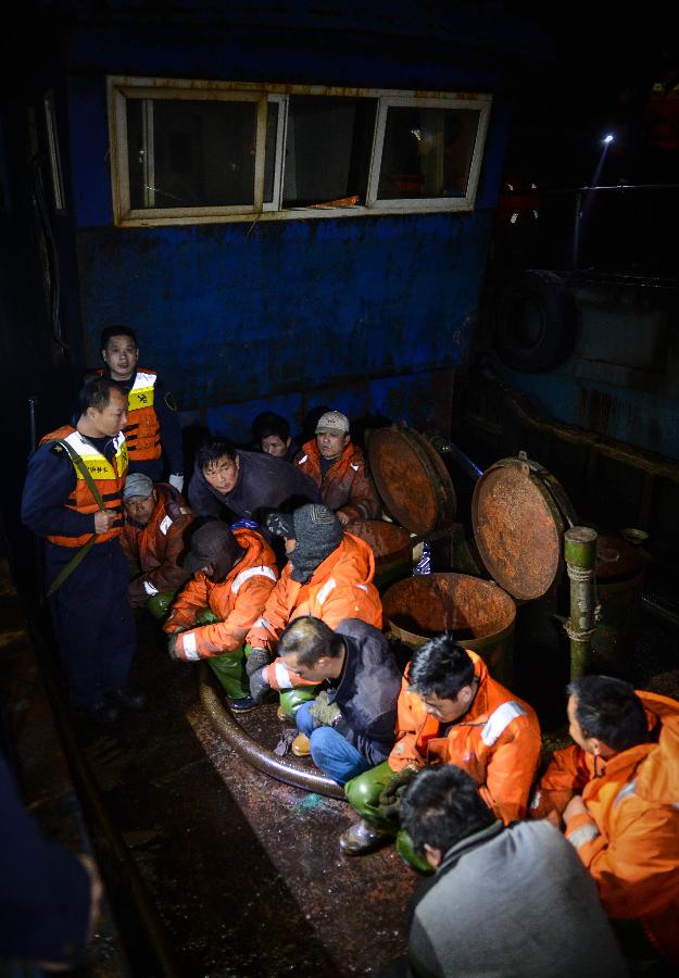Photo taken on March 29, 2013 shows police watching over smugglers on a boat offshore east China's Zhejiang Province. A gangs smuggling case involving 15,000 tons of refined oil worthy over 100 million Yuan (approximately 15.9 million U.S. dollars) was seized here on Sunday, as announced by Hangzhou customs on March 31, it is the biggest ever gangs smuggling case offshore Zhejiang province. (Xinhua/Xu Yu)