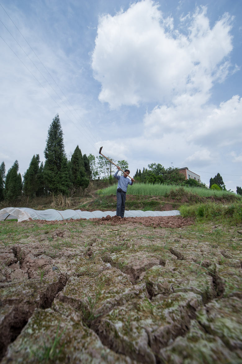 Zeng Kaihua, a villager from Rongchang county of Chonqing works on the cracking land on March 26, 2013. Spring drought hit several counties in southwest China's Chongqing. (Xinhua/Chen Cheng)