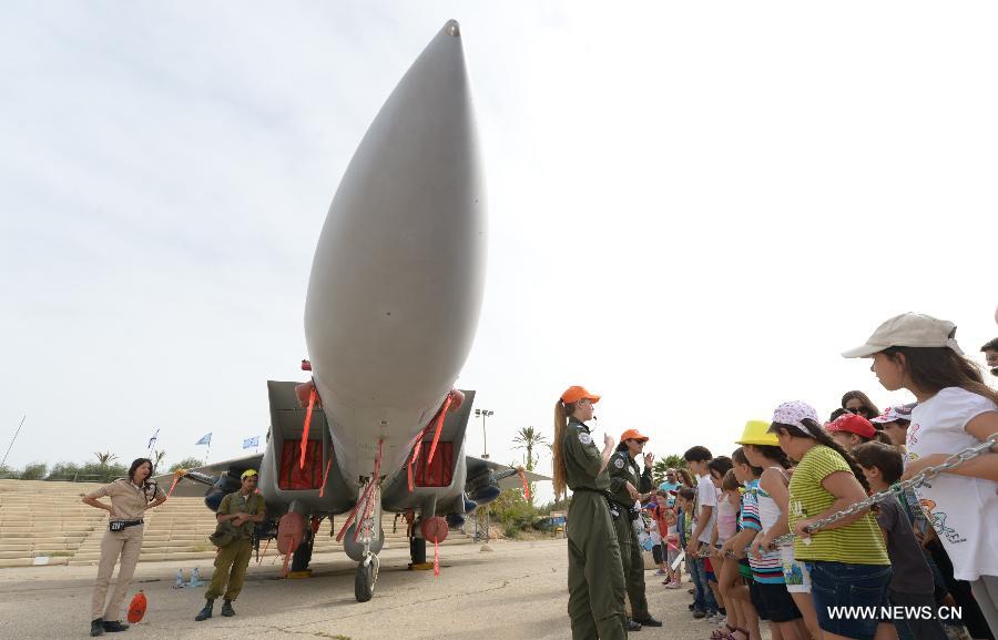 Israeli children watch an F-15I fighter jet of Israeli Air Force (IAF) at the Air Force Museum near the southern Israel city of Beer Sheva on March 31, 2013. More than 40 scenic spots in Israel including top museums are open to the public for free during the Passover. (Xinhua/Yin Dongxun) 