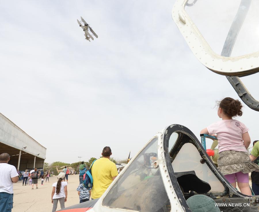 Israeli visitors watch an aircraft of Israeli Air Force (IAF) performing aerobatics for the Jewish fetival of Passover at the Air Force Museum near the southern Israel city of Beer Sheva on March 31, 2013. More than 40 scenic spots in Israel including top museums are open to the public for free during the Passover. (Xinhua/Yin Dongxun) 