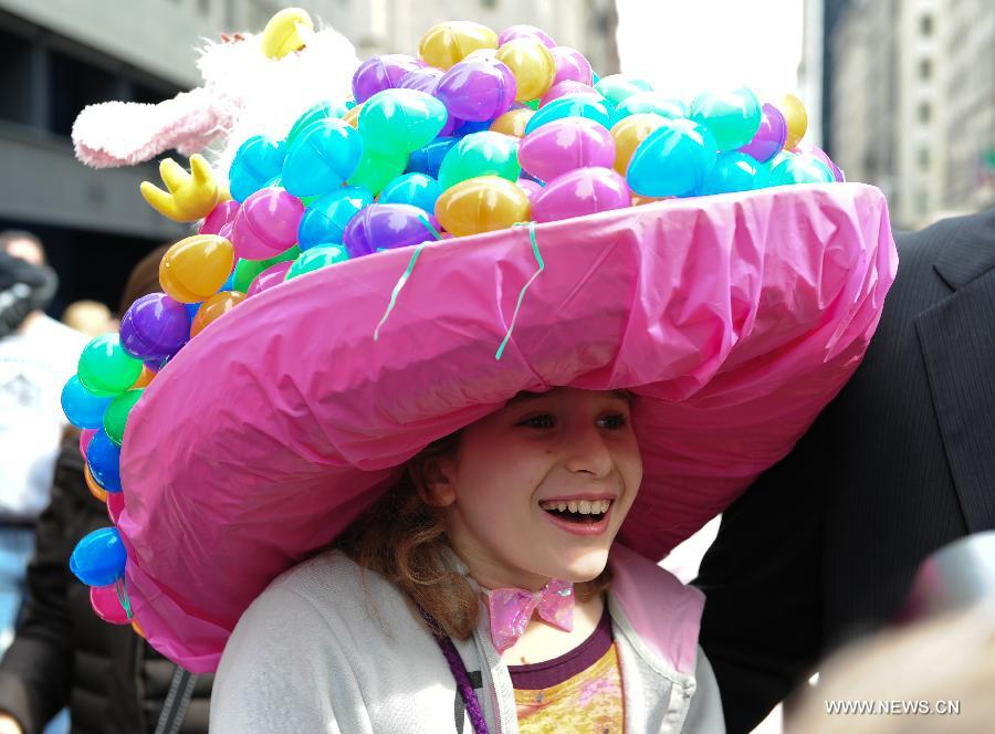 A girl wearing a hat full of Easter eggs takes part in the annual Easter Bonnet Parade held on the Fifth Avenue in Manhattan of New York, the United States, March 31, 2013. With a history of more than 100 years, the New York Easter Bonnet Parade is held annually on the 5th Avenue near the Saint Patrick's Cathedral. Adults, children and even pets in creative colorful bonnets and outfits participate in the event, which also attract thousands of New York residents and tourists. (Xinhua/Deng Jian) 