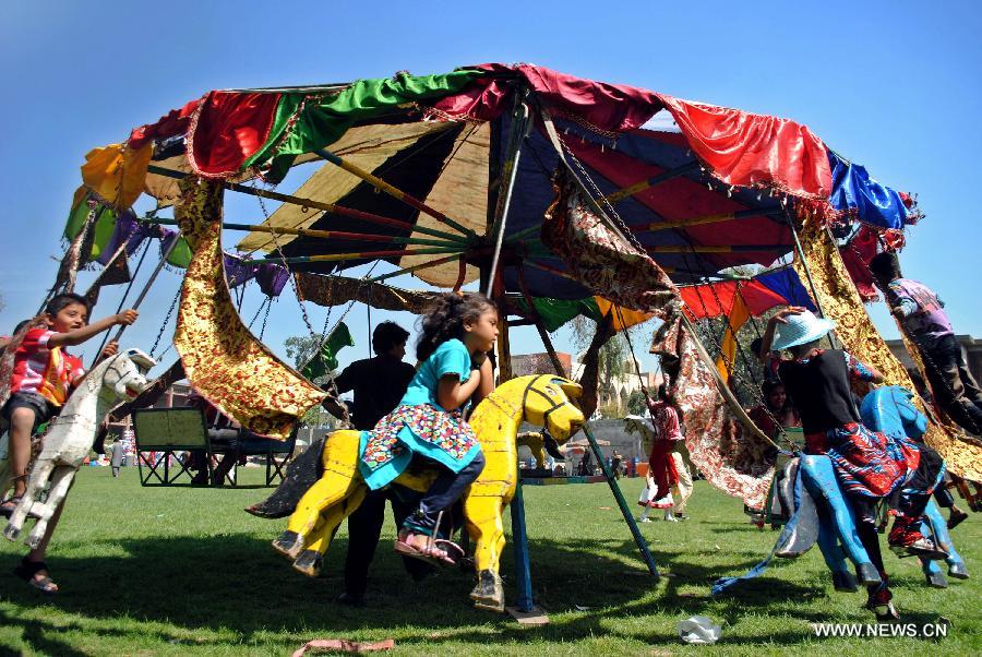 Pakistani Christian children enjoy swing ride during Easter celebrations in northwest Pakistan's Peshawar on March 31, 2013. (Xinhua/Umar Qayyum)