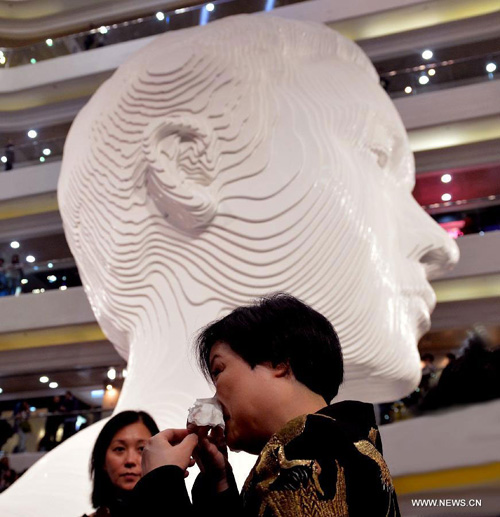 Fans take pictures at an exhibition for paying tribute to Cheung in Hong Kong, south China, March 30, 2013. The exhibition is held to mark the 10th anniversary of the death of Leslie Cheung, who leapt to his death from a hotel in Hong Kong on April 1, 2003. A total of 1,900,119 origami cranes, folded by fans around the world, are displayed inside a giant red cube, which broke the Guinness World Record as "the largest display of origami cranes". (Xinhua/Chen Xiaowei)