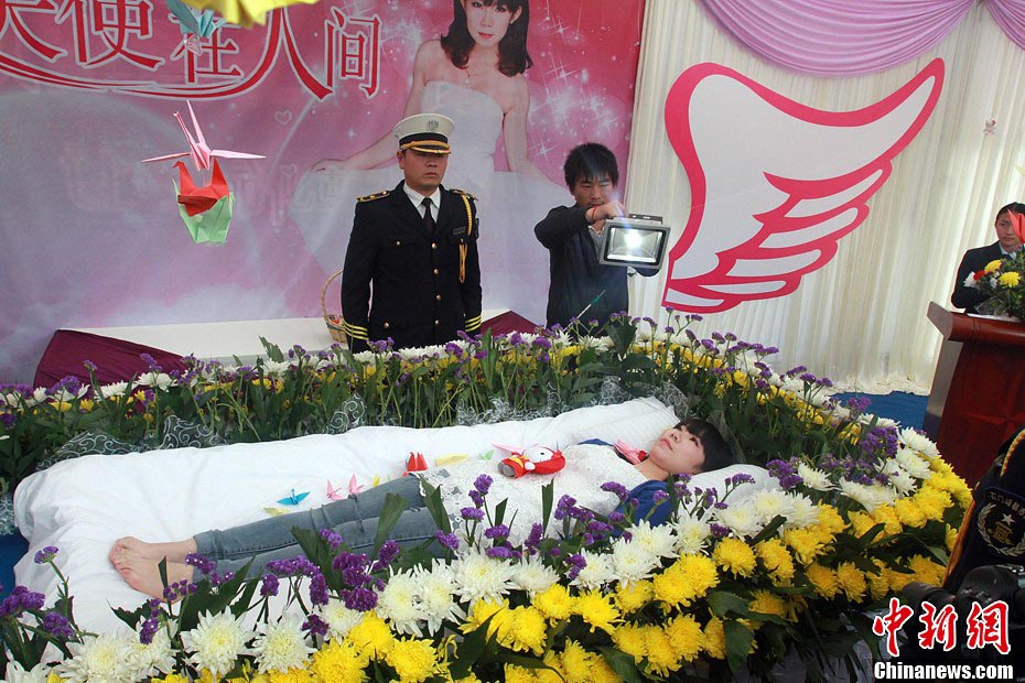 Zeng Jia, a 20-year-old college student takes part in a faux funeral in Wuhan, Central China's Hubei province, March 30, 2013. (Photo/CNS)