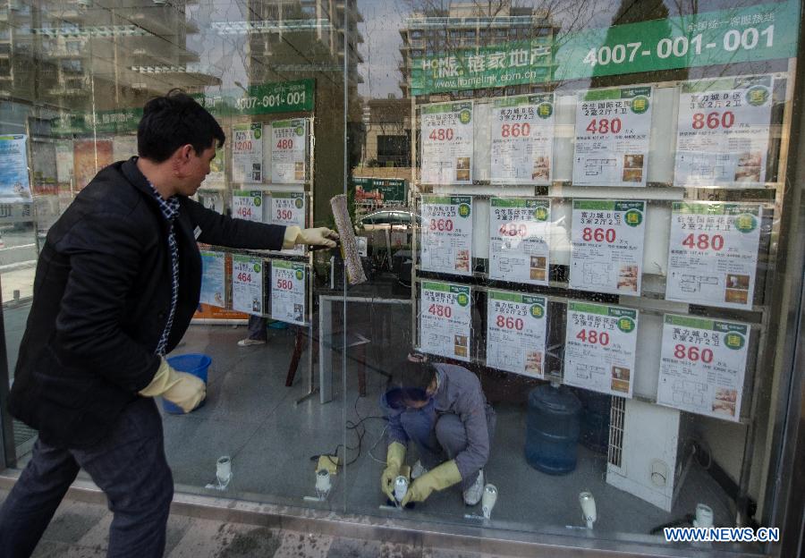 Housing agents take advantage of idle time to clean their store on the first working day after the Beijing government announced detailed property curbs in Beijing, capital of Beijing, April 1, 2013. The municipal government of Beijing on March 30 spelled out detailed rules aimed at cooling the property market following the central government's fresh regulatory plan earlier this month. Single adults with a permanent Beijing residence registration, who have not made purchases in the city before, are allowed to buy only one apartment, according to the announcement. Meanwhile, the city will raise down payments for second-home buyers and vow to strictly implement the 20-percent tax on capital gains from property sales. (Xinhua/Luo Xiaoguang)