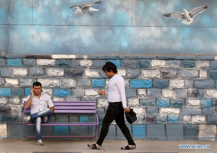 People are seen on a sidewalk in Ahvaz, capital of Iran's southwestern province of Khuzestan, on March 31, 2013. Khuzestan is the major oil-producing region of Iran and accounts for almost 90 percent of Iran's oil production.(Xinhua/Ahmad Halabisaz)
