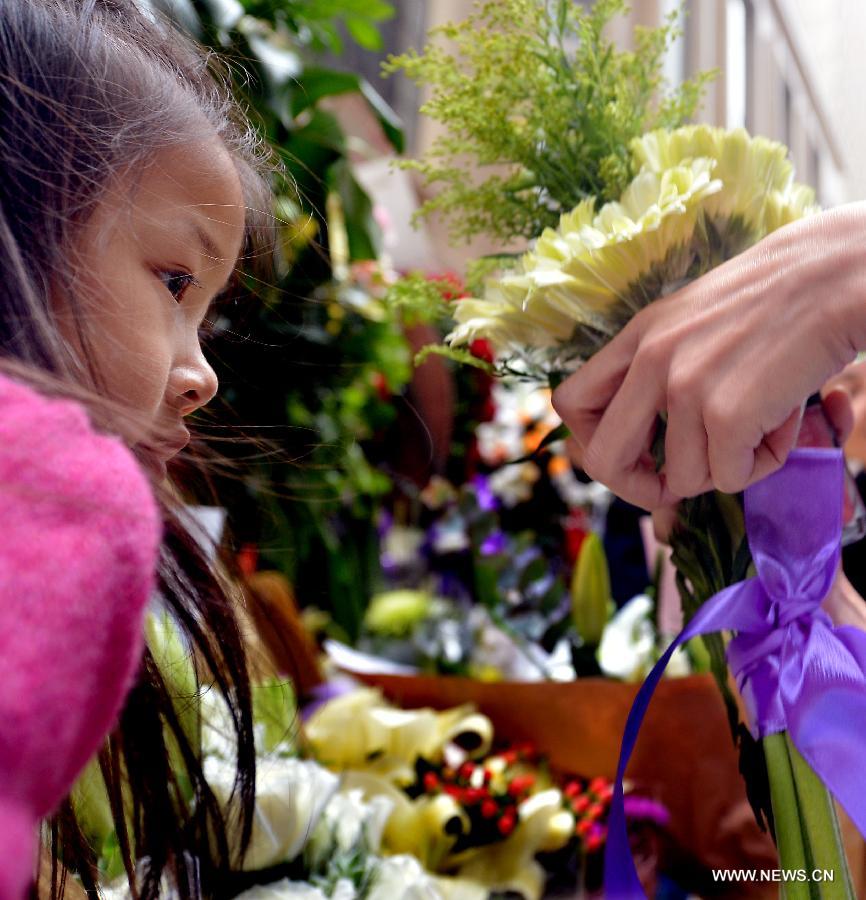 A little fan of late Hong Kong singer and actor Leslie Cheung commemorates the 10th anniversary of his death outside the Mandarin Oriental Hotel in Hong Kong, south China, April 1, 2013. Leslie killed himself by leaping off a balcony on the 24th floor of the Mandarin Oriental Hotel on April 1, 2003. (Xinhua/Chen Xiaowei) 