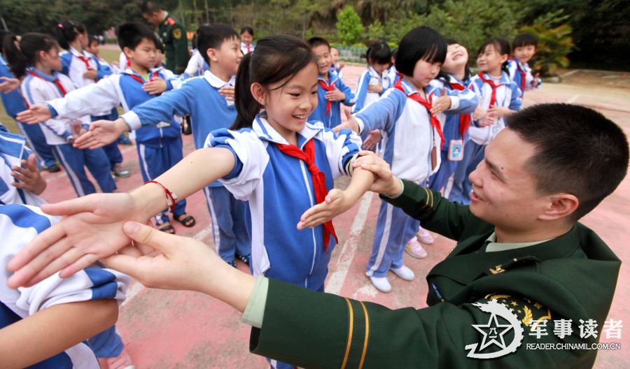 A soldier teaches pupils of the "Golden Fields" Primary School in Shenzhen City to make safety gestures on March 25, 2013. The servicemen of the 21st Squadron of the 7th Detachment under the Armed Police Frontier Defense Contingent in Guangdong Province came to the “Golden Fields” Primary School in Shenzhen City on the morning of March 25 to mark the 18th National Safety Education Day for Primary and High School Students together with pupils in the school. (chinamil.com.cn/Liao Jian)