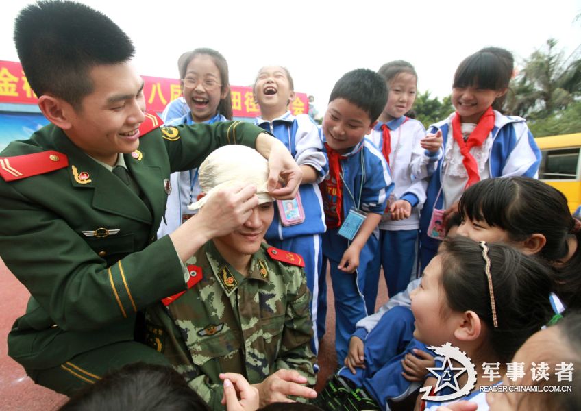 Two soldiers demonstrate to the pupils in the "Golden Fields" Primary School in Shenzhen City how to bind up the wound in a self-rescue operation on March 25, 2013. The servicemen of the 21st Squadron of the 7th Detachment under the Armed Police Frontier Defense Contingent in Guangdong Province came to the "Golden Fields" Primary School in Shenzhen City on the morning of March 25 to mark the 18th National Safety Education Day for Primary and High School Students together with pupils in the school. (chinamil.com.cn/Zhu Tingwei)