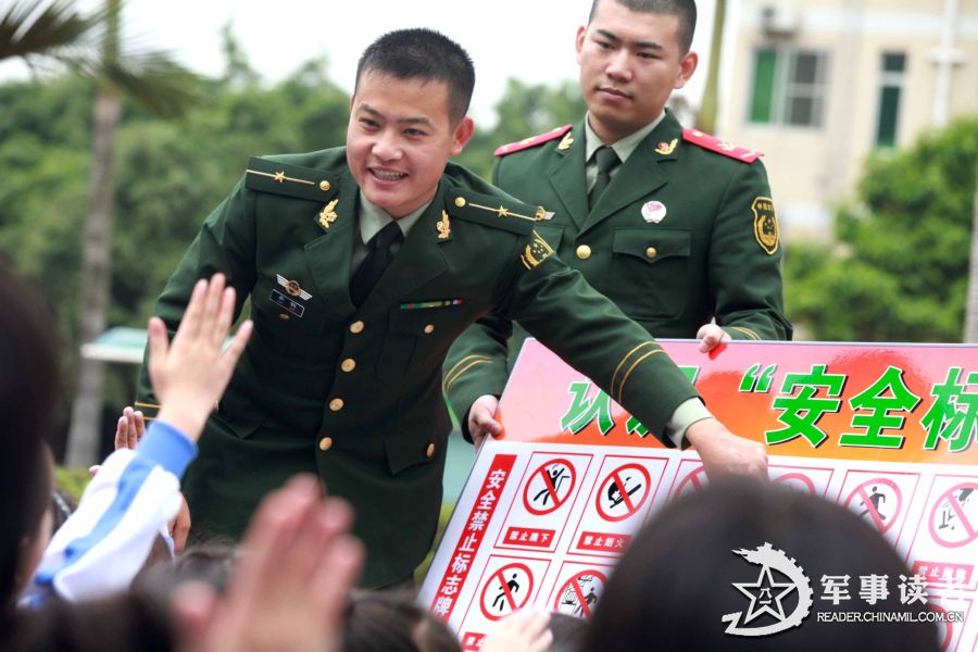 An officer points a logo in a safety logo identification competition in the "Golden Fields" Primary School in Shenzhen City. The servicemen of the 21st Squadron of the 7th Detachment under the Armed Police Frontier Defense Contingent in Guangdong Province came to the "Golden Fields" Primary School in Shenzhen City on the morning of March 25 to mark the 18th National Safety Education Day for Primary and High School Students together with pupils in the school. (chinamil.com.cn/Lin Guohong)