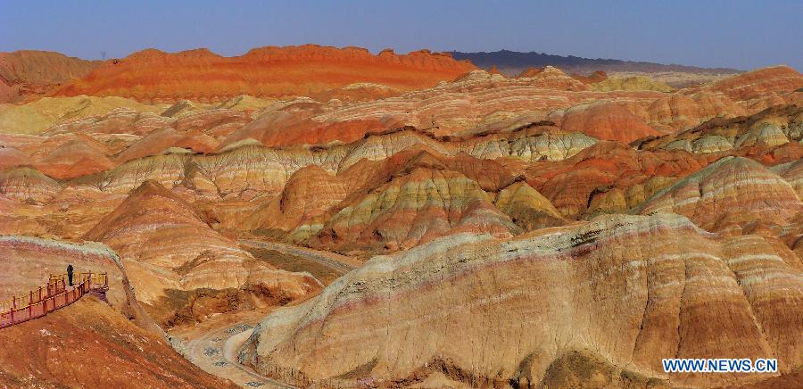 A visitor views the Danxia Landform in Zhangye City, northwest China's Gansu Province, April 1, 2013. Danxia is a special landform from reddish sandstone that has been eroded over time into a series of mountains surrounded by curvaceous cliffs and many unusual rock formations. (Xinhua/Shi Youdong)