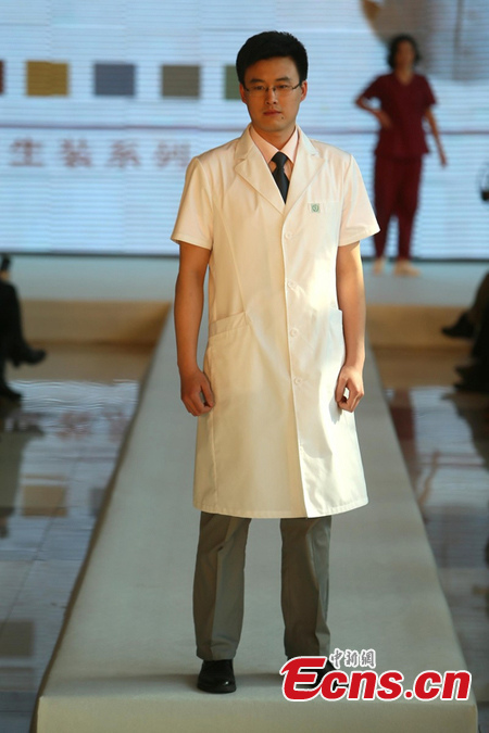 A man displays a uniform for doctor in Beijing, April 1, 2013. Beijing planed to change hospital uniforms for doctors, nurses, logistics workers and patients. (photo / CSN)