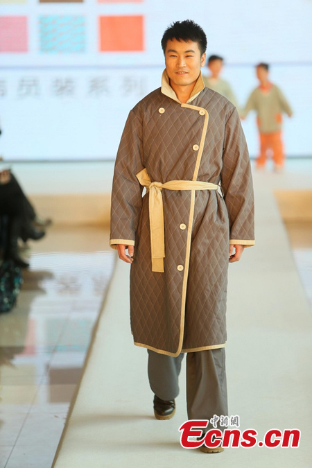 A man displays a uniform for patient in Beijing, April 1, 2013. Beijing is planning to change hospital uniforms for doctors, nurses, logistics workers and patients. (photo / CSN)