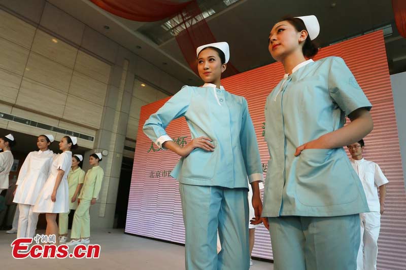 Two women display uniforms for nurse in Beijing, April 1, 2013. Beijing is planning to change hospital uniforms for doctors, nurses, logistics workers and patients. (photo / CSN)