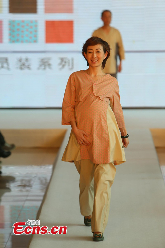 A woman displays a uniform for pregnant patient in Beijing, April 1, 2013. Beijing is planning to change hospital uniforms for doctors, nurses, logistics workers and patients. (photo / CSN)