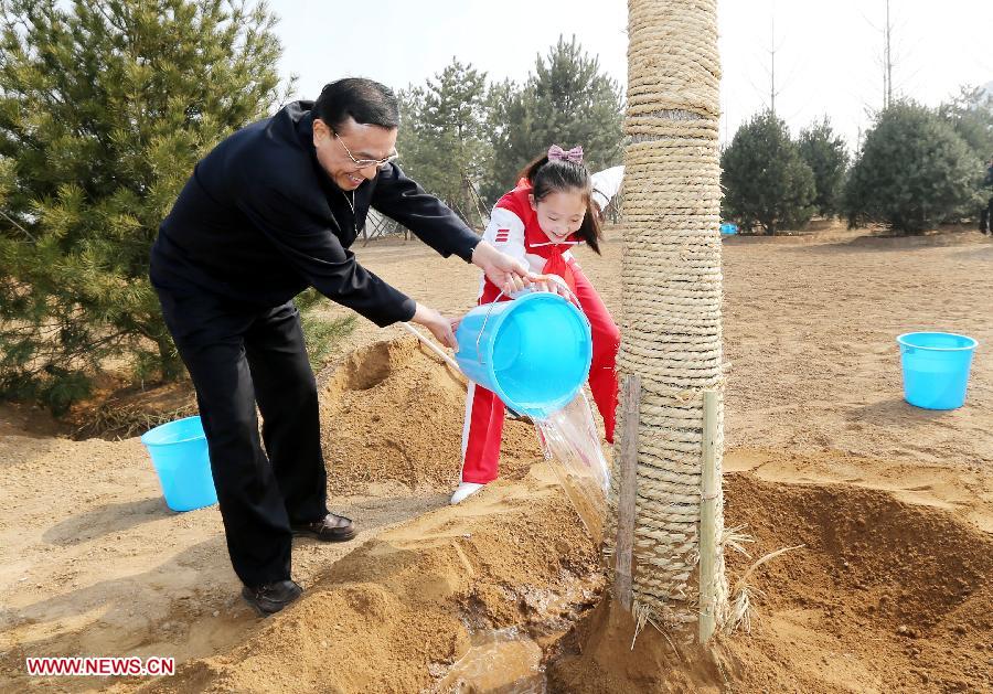 Li Keqiang (L) waters a tree together with a pupil during a tree-planting event in Fengtai District in Beijing, capital of China, April 2, 2013. Chinese top leaders Xi Jinping, Li Keqiang, Zhang Dejiang, Yu Zhengsheng, Liu Yunshan, Wang Qishan and Zhang Gaoli joined in the tree planting event here on Tuesday. (Xinhua/Yao Dawei)