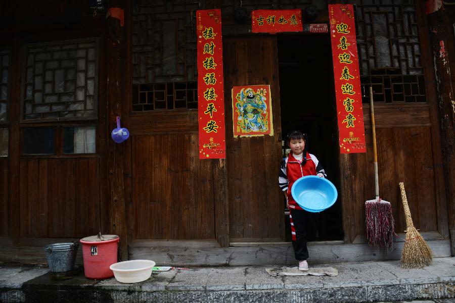 A girl carring a basin walks out a house in Zhenyuan County, southwest China's Guizhou Province, March 31, 2013. The county could date back 2,280 years with the Wuyang River running through it. As many ancient style architectures were built along the river, the ancient town was dubbed as "Oriental Venice" by tourists. (Xinhua/Hu Yan) 