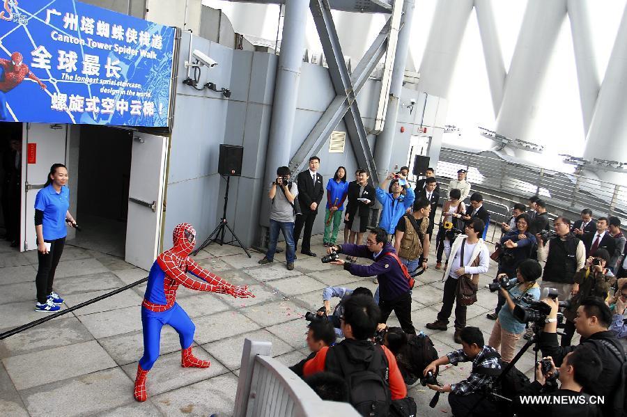 A working staff dressed up like a spider-man interacts with audience in the opening ceremony of the Canton Tower Spider Walk in Guangzhou, capital of south China's Guangdong Province, April 2, 2013. The 1,000-meter-long Spider Walk locates at the 168-meter to 334.4-meter height of Canton Tower, with a transparent floor made up of 90 pieces of glasses. Visitors would get a general view of the scenery of Guangzhou City from the Spider Walk. (Xinhua/Shen Dunwen)