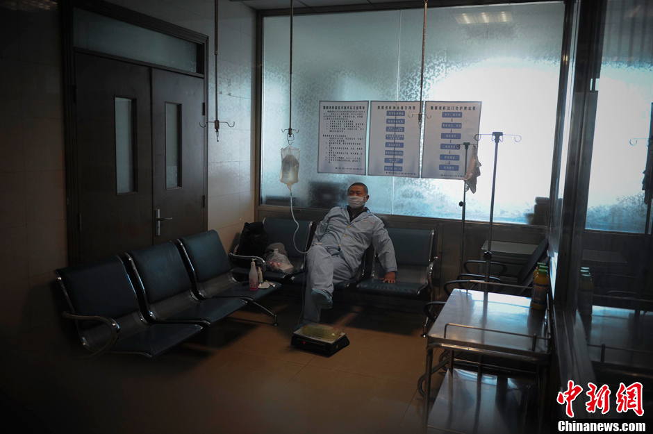 The nurse does a favor to Qi and let him finish his peritoneal dialysis in hospital. The dialysis unit is much more sanitary than his rented room. (Chinanews.com/ Liu Xin)