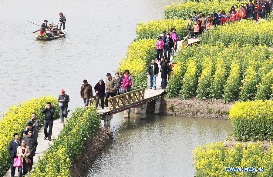 Tourists enjoy cole flowers at the Qiandao Cole Flower Scenic Spot in Ganggu Township of Xinghua City, east China's Jiangsu Province, April 3, 2013. (Xinhua/Zhou Haijun)
