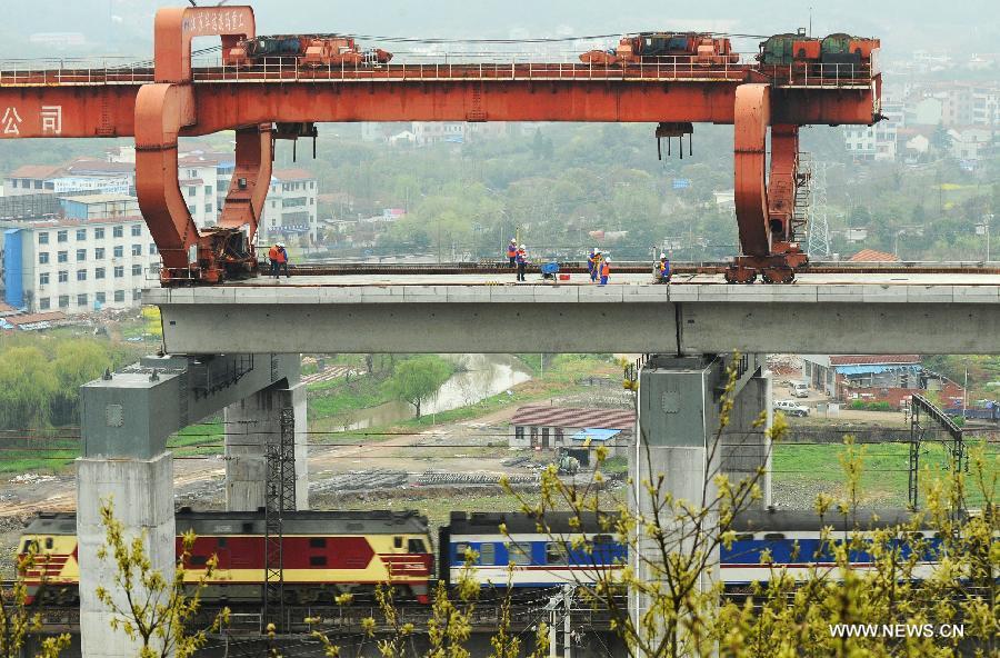 Technians work at the construction site of the Yiwu section of the Hangzhou-Changsha High-speed Rail on the Dongte Bridge in Yiwu, east China's Zhejiang Province, March 26, 2013. The 920-kilometer-long Hangzhou-Changsha High-speed Rail would shorten the travelling time between east China's Hangzhou and central China's Changsha from 6.3 hours to 3 hours once completed. (Xinhua/Tan Jin)