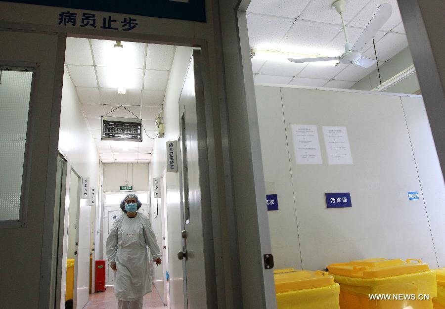 A health worker wearing an isolation suit works at the "Fever Clinic" in the Sixth People's Hospital in Shanghai, east China, April 3, 2013. The city government launched a third-level contingency plan for flu prevention and control on Tuesday. By far, no new case of pneumonia caused by unknown reasons has been reported. (Xinhua/Pei Xin)