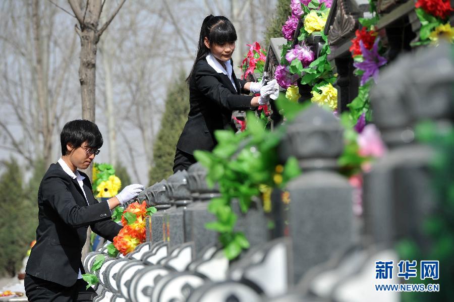 Funeral directors Wang Na (L) and Lu Yufei clean tombstones two days ahead of Qingming Festival, or Tomb Sweeping Day, in a cemetery in Yinchuan city, capital of Northwest China's Ningxia Hui autonomous region, April 2, 2013. Wang and Lu, both born in the 1990s, are among the city's first batch of female funeral directors helping to prepare for the day when the country honors the dead. Their services include reading laments, attending funerals, tomb sweeping and psychological counseling. (Photo/Xinhua)
