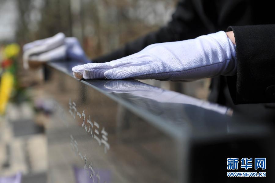 Funeral director Wang Na uses her white gloves to clean the tombstone in a cemetery in Yinchuan city, capital of Northwest China's Ningxia Hui autonomous region, on April 2, 2013, two days before the country's Qingming Festival, or Tomb Sweeping Day when people honor the dead.(Photo/Xinhua) 