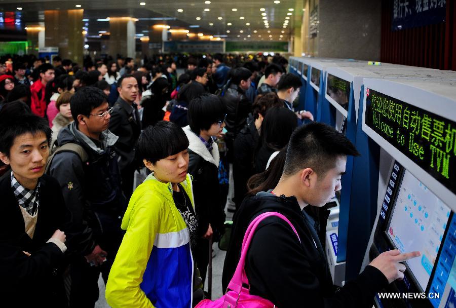Passengers buy tickets at the Tianjian Railway Station in Tianjin Municipality, north China, April 3, 2013. The railway station witnessed a travel peak on Wednesday, ahead of the country's three-day holiday for tomb sweeping, which will start on April 4. (Xinhua/Zhang Chaoqun)