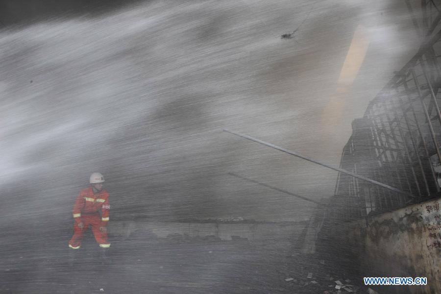 A fireman is seen amid sprayed water at the Zhangwan Farmers Market in Shiyan City, central China's Hubei Province, April 3, 2013. A fire broke out around 2:20 p.m. at the market and was put out later, leaving one person injured. (Xinhua)