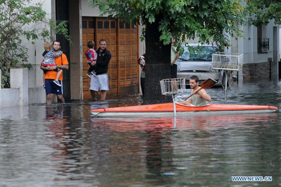 Residets walk through a flooded area after a storm, in Tolosa, La Plata, 63 km south of Buenos Aires, Argentina, on April 3, 2013. At least 46 people have died due to heavy storms in La Plata, and another 3,000 have been evacuated. (Xinhua/TELAM) 