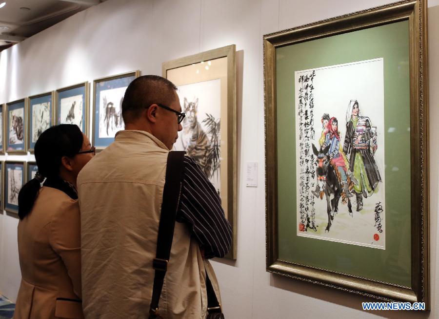 Visitors look at a painting by Huang Zhou estimated at a price of 1.6 million to 2.6 million HKD (about 200,000 to 300,000 U.S. dollars) during the preview of the Hong Kong 2013 Spring Auctions held by China Guardian Auctions Co.Ltd in Hong Kong, south China, April 3, 2013. The two-day auctions will start on April 4, with over 300 pieces of paintings and calligraphy as well as ceramic artworks. (Xinhua/Li Peng) 