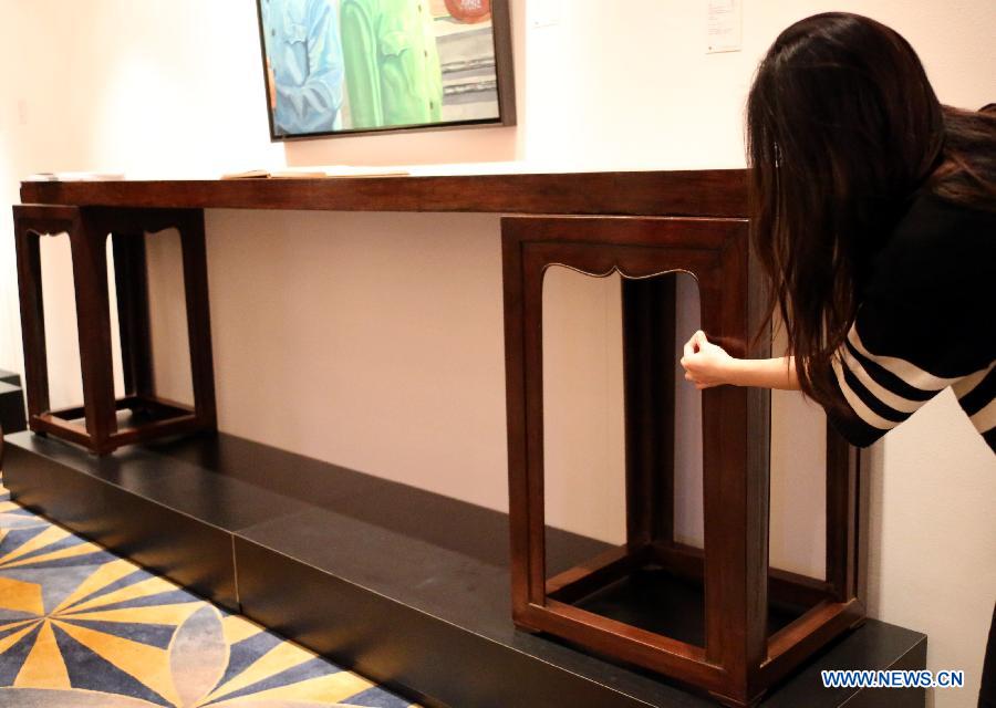 A visitor looks at a piece of furniture from Qing Dynasty (1644-1911) estimated at a price of 12 million to 22 million HKD (about 1.5 million to 2.8 million U.S. dollars) during the preview of the Hong Kong 2013 Spring Auctions held by China Guardian Auctions Co.Ltd in Hong Kong, south China, April 3, 2013. The two-day auctions will start on April 4, with over 300 pieces of paintings and calligraphy as well as ceramic artworks. (Xinhua/Li Peng) 