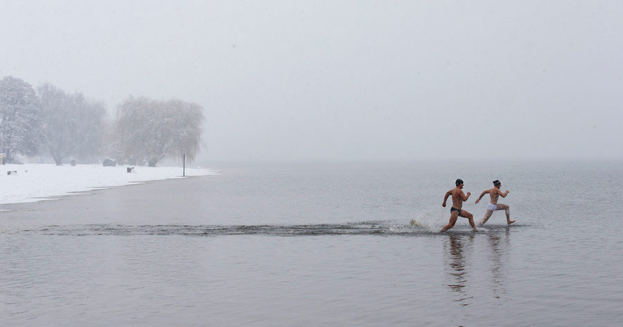 Two men run to swim at Berlin's Wannsee lido on March 29, 2013. The Strandbad Wannsee opened the annual swimming season with temperatures of 39 degrees Fahrenheit on March 29. (Xinhua/Reuters)