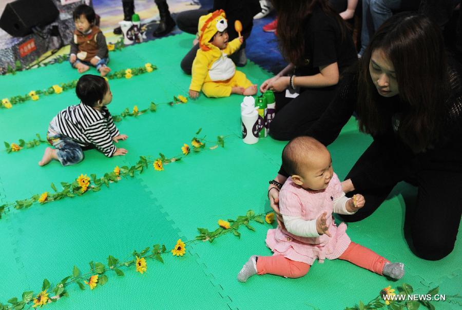 Babies participates in a crawl competition held in a shopping mall in Hong Kong, south China, April 4, 2013. Many parents took their children to the event here on Thursday. (Xinhua/Lui Siu Wai)