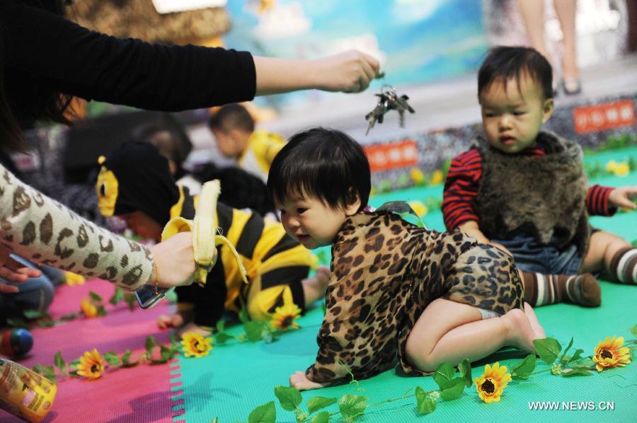 Babies participates in a crawl competition held in a shopping mall in Hong Kong, south China, April 4, 2013. Many parents took their children to the event here on Thursday. (Xinhua/Lui Siu Wai)