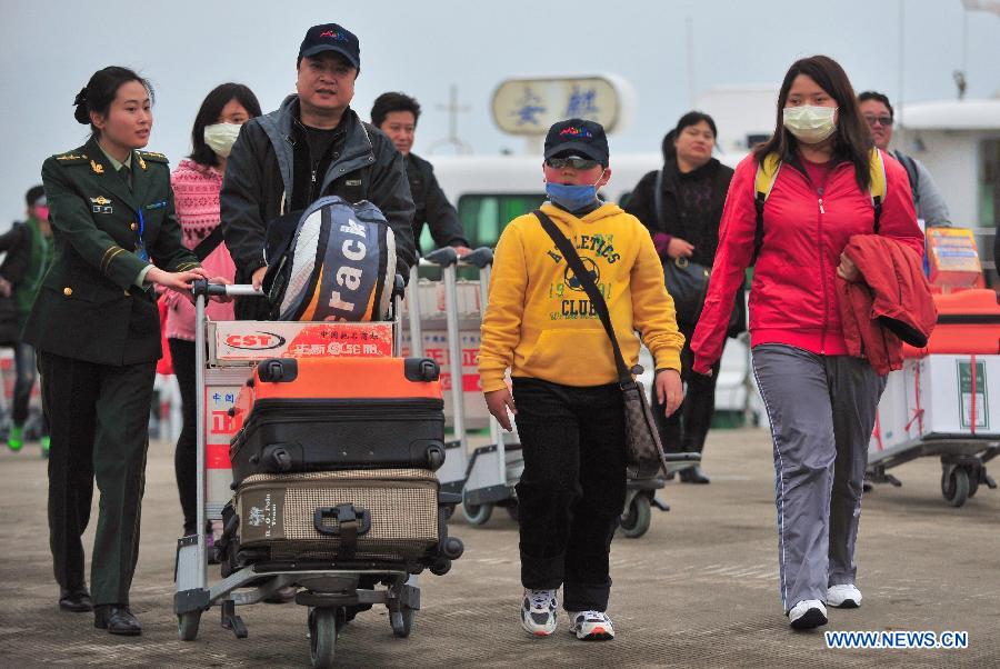 An officer (1st L) offers service for a family from Taiwan who returned to hometown for tomb-sweeping at Mawei Port, southeast China's Fujian Province, April 4, 2013. A green channel is set up during the Qingming Festival to facilitate people from Taiwan who returned to Mazu and Mawei in Fujian for tomb-sweeping and mourning for their deceased family members. (Xinhua/Wei Peiquan) 