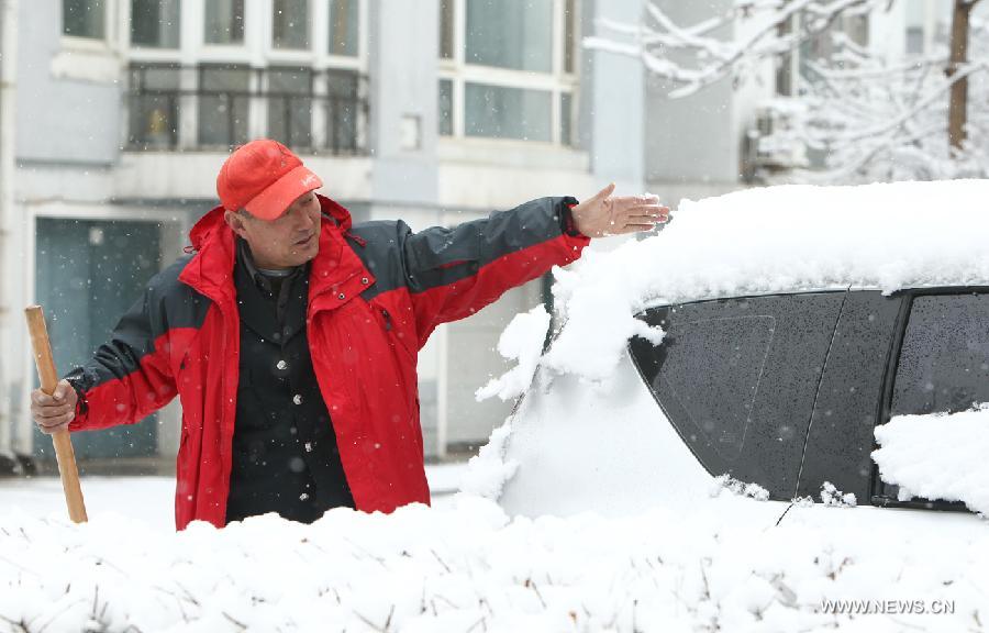 A man cleans snow on a car at a community in Chaoyang City, northeast China's Liaoning Province, April 5, 2013. While many parts of China have entered a blossoming season, Chaoyang experienced a heavy snowfall on Friday. (Xinhua/Qiu Yijun)