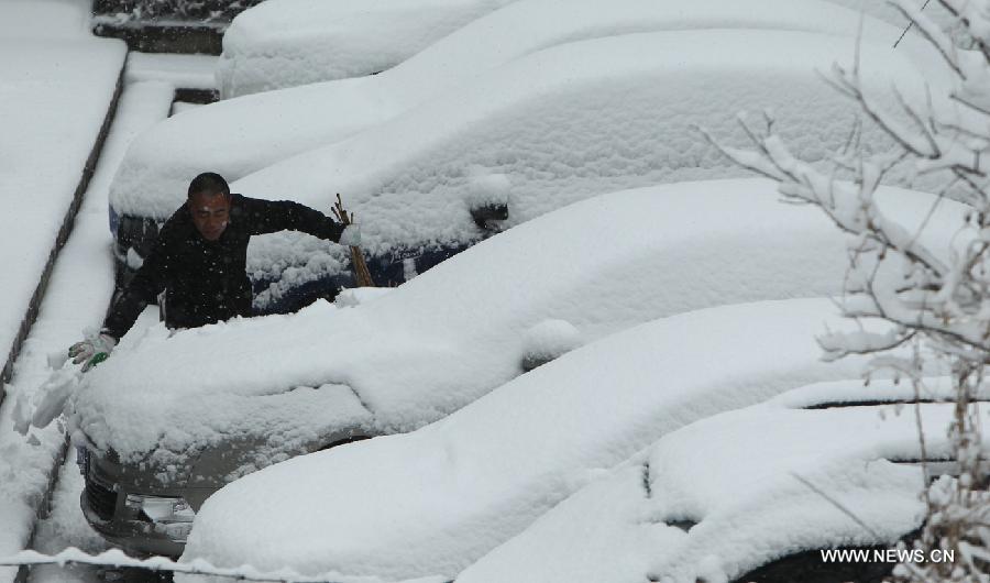 A man cleans snow on a car at a community in Chaoyang City, northeast China's Liaoning Province, April 5, 2013. While many parts of China have entered a blossoming season, Chaoyang experienced a heavy snowfall on Friday. (Xinhua/Qiu Yijun) 