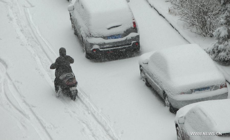 A local resident rides in snow in Chaoyang City, northeast China's Liaoning Province, April 5, 2013. While many parts of China have entered a blossoming season, Chaoyang experienced a heavy snowfall on Friday. (Xinhua/Qiu Yijun)  