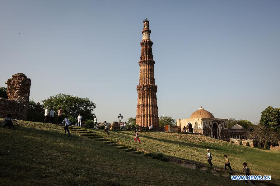 People visit the Qutab Minar in New Delhi, India, on April 5, 2013. Qutab Minar, a UNESCO World Heritage Site, is the tallest minaret in India. It is 75.56 metres high with a base a diameter of 14.3 metres, which narrows to 2.7 metres at the top storey. The minar is made of red sandstone and marble, and covered with intricate carvings. The construction of Qutab Minar started in 1193 by Qutub-ud-din Aibak and was completed by his inheritor Iltutmish. It is surrounded by several other ancient and medieval structures and ruins, collectively known as the Qutub complex, which attracts many visitors till now. (Xinhua/Zheng Huansong)