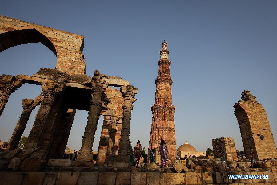 People visit the Qutab Minar in New Delhi, India, on April 5, 2013. Qutab Minar, a UNESCO World Heritage Site, is the tallest minaret in India. It is 75.56 metres high with a base a diameter of 14.3 metres, which narrows to 2.7 metres at the top storey. The minar is made of red sandstone and marble, and covered with intricate carvings. The construction of Qutab Minar started in 1193 by Qutub-ud-din Aibak and was completed by his inheritor Iltutmish. It is surrounded by several other ancient and medieval structures and ruins, collectively known as the Qutub complex, which attracts many visitors till now. (Xinhua/Zheng Huansong)