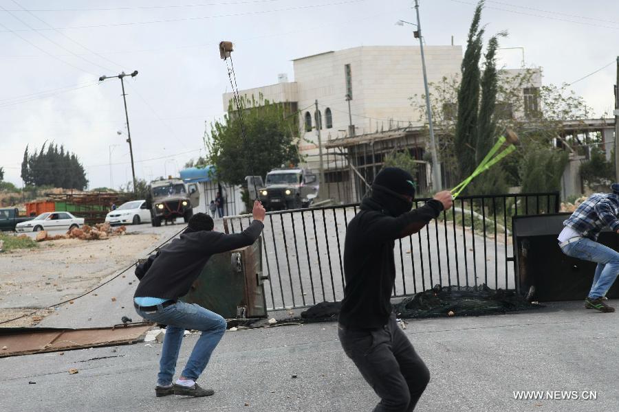 Palestinian protesters throw stones at Israeli soldiers during clashes in the West Bank city of Hebron on April 5, 2013. (Xinhua/Mamoun Wazwaz)