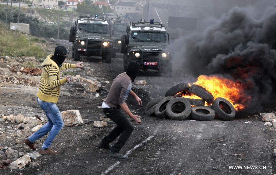 Palestinian protesters hurl stones at Israeli soldiers during a protest against the expanding of Jewish settlements in Kufr Qadoom village near the West Bank city of Nablus on Apr. 5, 2013 (Xinhua/Nidal Eshtayeh)
